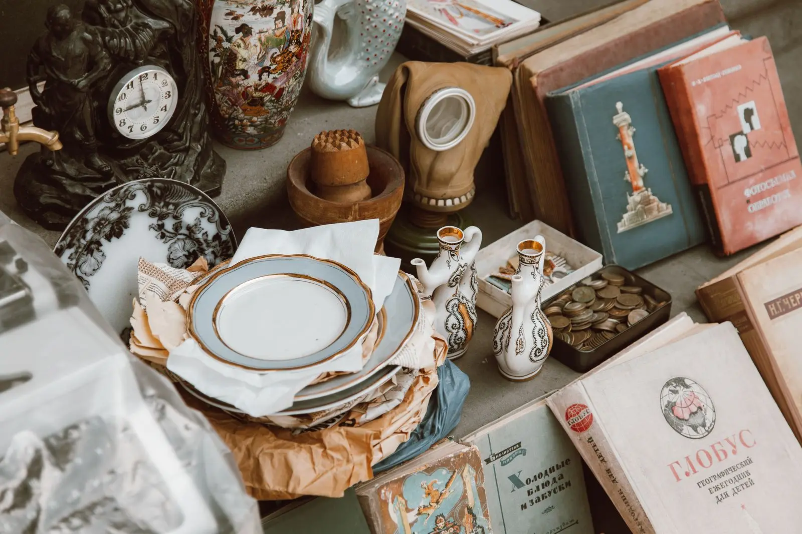 Composition d’objets anciens avec livres, vaisselle, vases et horloge